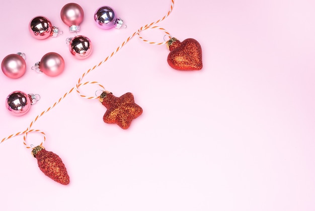 New Years garland of Christmas toys on a pink background