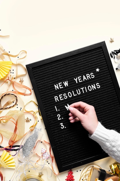 Photo new years resolution on the chalkboard new year lettering on chalkboard with hand top view