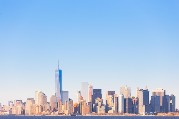 New York City Manhattan downtown skyline at sunset with skyscrapers illuminated over Hudson River panorama. Horisontal composition, copy space.