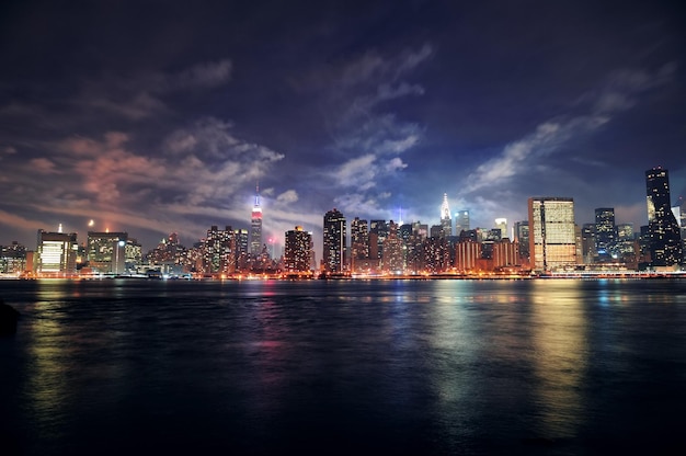 New York City Manhattan midtown panorama at dusk with skyscrapers illuminated over east river