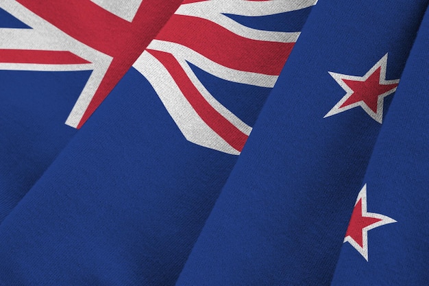 New Zealand flag with big folds waving close up under the studio light indoors The official symbols and colors in banner