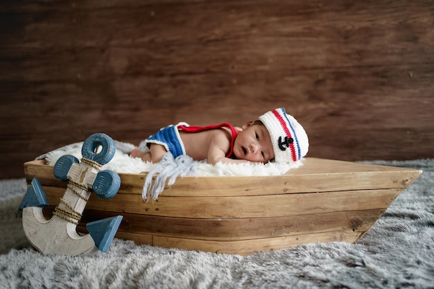 Newborn baby boy wearing a white and blue sailor hat