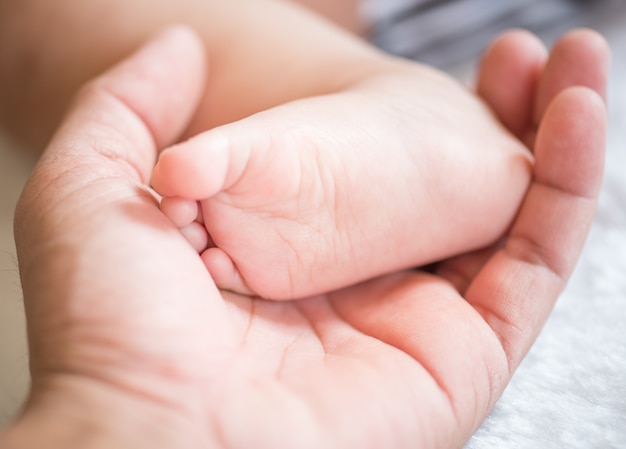 newborn baby feet on male hand