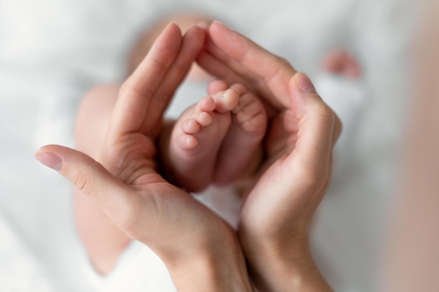 Newborn baby feet in mother's hands isolated on white. childhood concept.