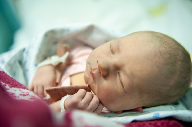 A newborn baby on the first day of its birth in the maternity hospital