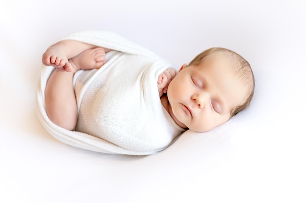 newborn baby girl in a basket sleeping sweetly on a white blanket with a stuffed toy bunny closeup portrait