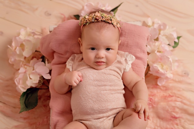 Newborn baby girl sleeping in bed with pink garden flowers