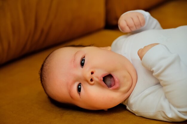 Newborn baby lies on the dewan newborn baby shows different emotions