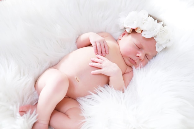 A newborn baby lies in her mother's arms A beautiful baby of European appearance is sleeping