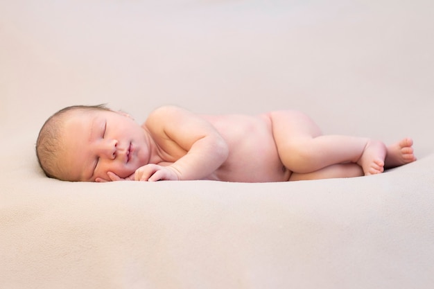 Newborn baby sleeps and smiles. close up portrait of beautiful sleeping baby