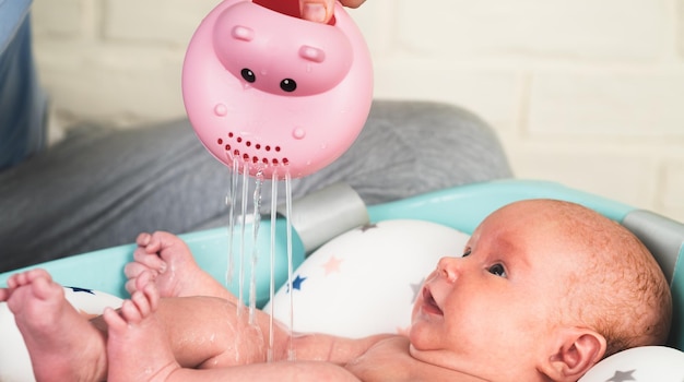 A newborn baby takes a bath A lovely child is undergoing military training for the first time The concept of children and hygiene