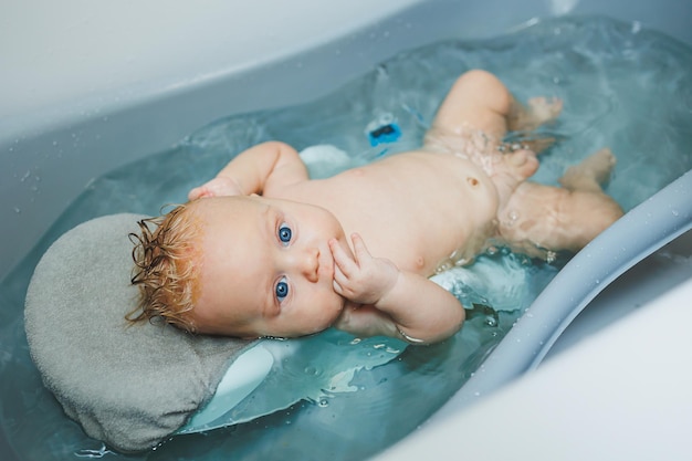 A newborn baby takes a bath Parents bathe the child The newborn is bathed The newborn is smiling Baby care