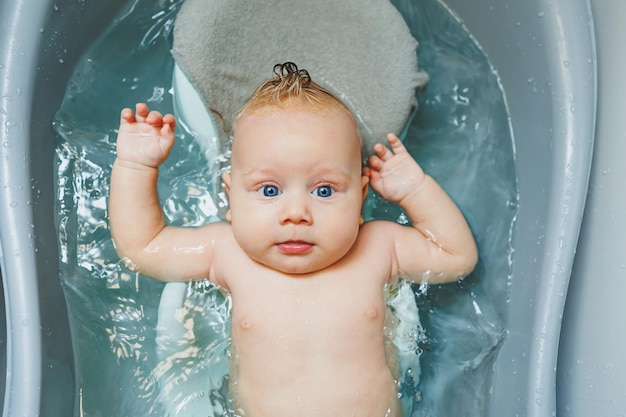 A newborn baby takes a bath Parents bathe the child The newborn is bathed The newborn is smiling Baby care