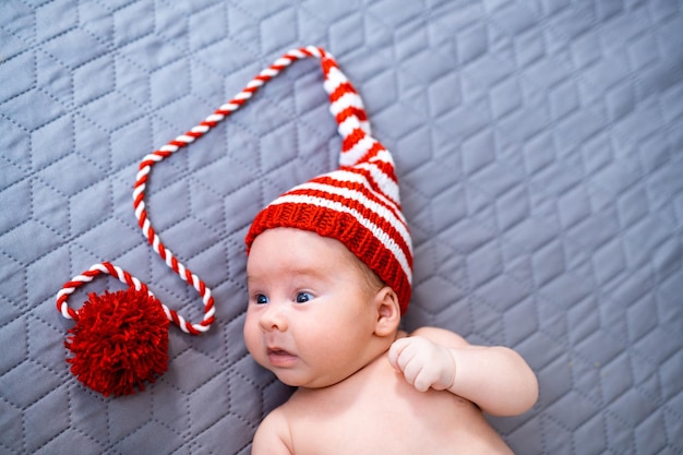 Newborn baby wearing a knitted Christmas elf hat