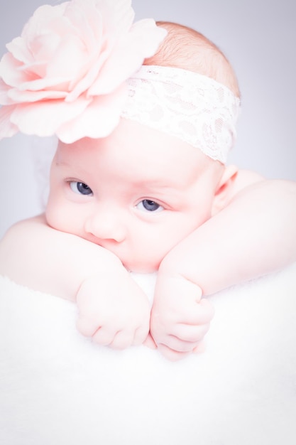 Newborn baby with a headband on the head lying on a blanket Cute newborn baby