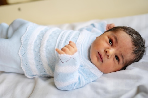 Newborn boy in the hospital first day of life opening his eyes for the first time