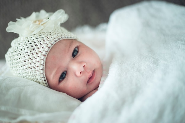 Newborn child relaxing in bed after bath or shower. Nursery for children.