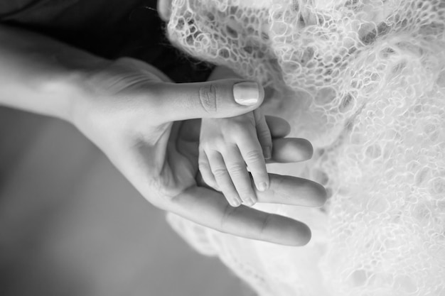 Newborn children's hand in mother hand Mom and her Child Happy Family concept Beautiful conceptual image of Maternity