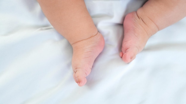 Newborn chubby legs and foots Beautiful conceptual image of motherhood and baby