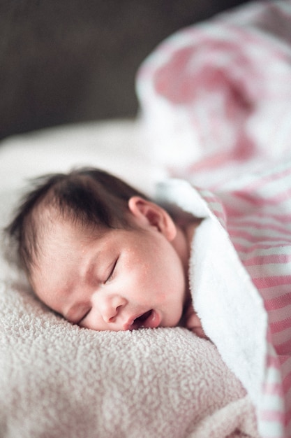 newborn cute girl sleeping on a pink background