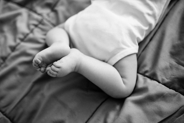 Newborn feet. The child is lying on the bed.