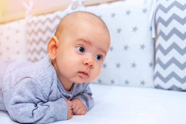 The newborn lies on his stomach with his head raised, the development of the baby