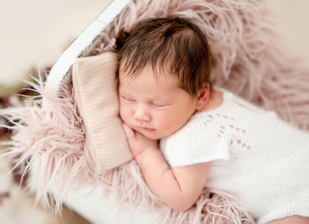 Newborn sleeping in tiny bed