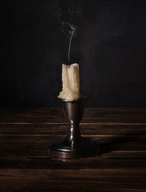 Newly extinguished candle are standing on a wooden table