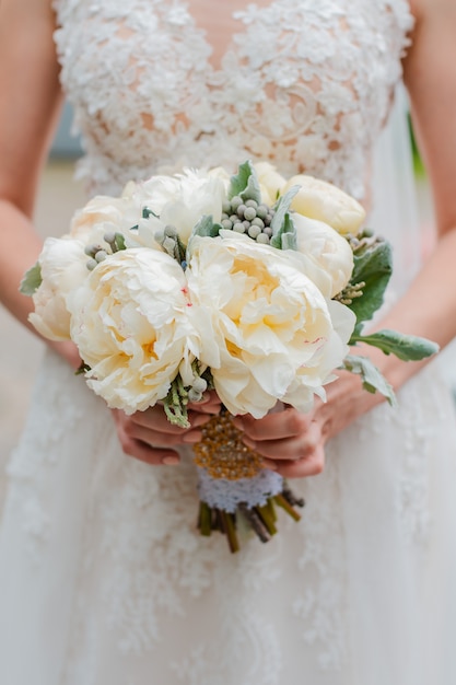 Newly married couple. Wedding day. Bouquet of the bride in the hands, the groom's embrace.