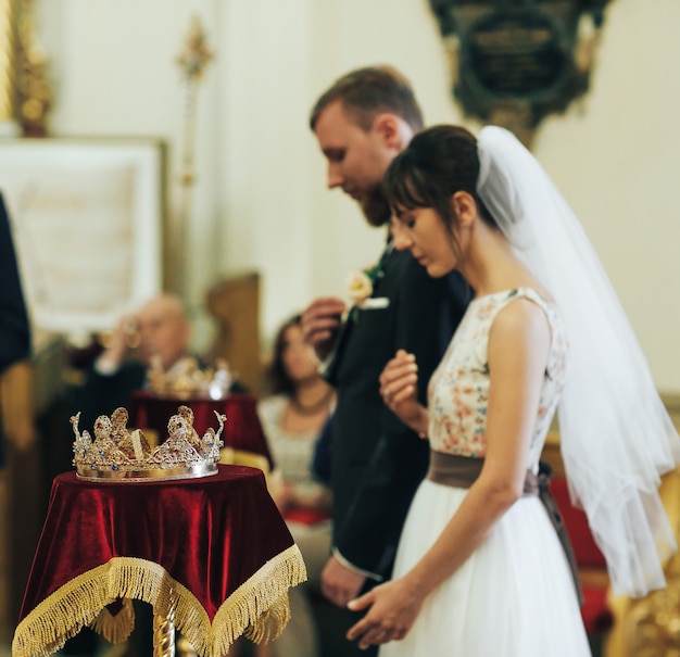 Newlyweds in the church. Priest celebrate wedding mass at the church