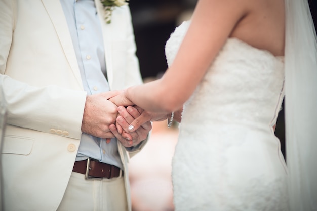 Newlyweds exchange rings, groom puts the ring on the bride's hand