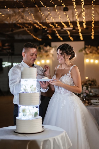 Newlyweds happily cut laugh and taste the wedding cake