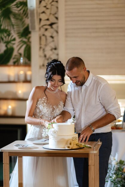 Newlyweds happily cut laugh and taste the wedding cake