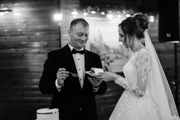 Newlyweds happily cut and taste the wedding cake