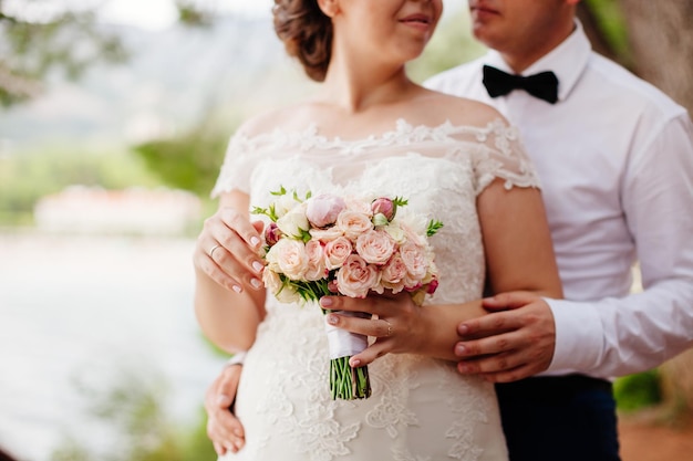 Newlyweds holding wedding bouquet together