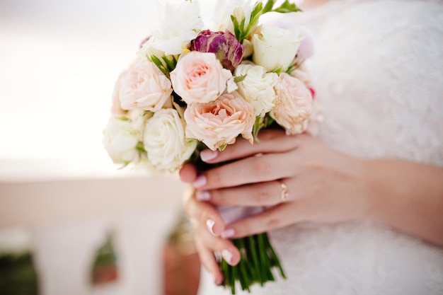 Newlyweds holding wedding bouquet together