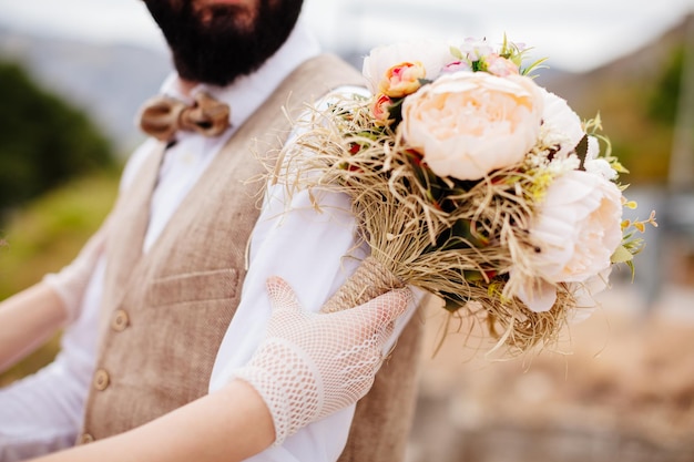 Newlyweds holding wedding bouquet together