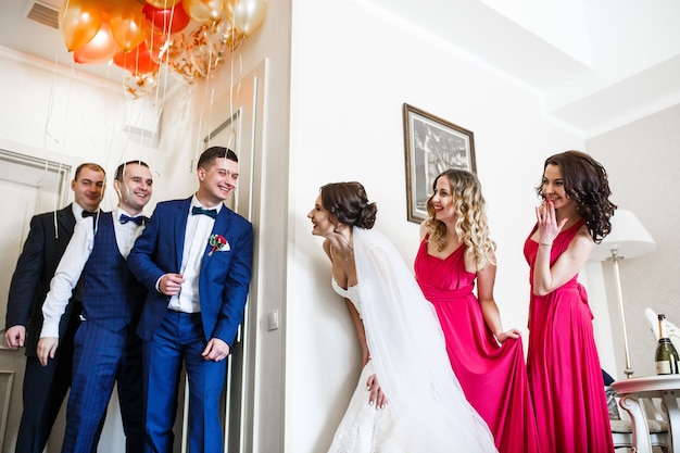 Newlyweds pose with friends in the hotel room