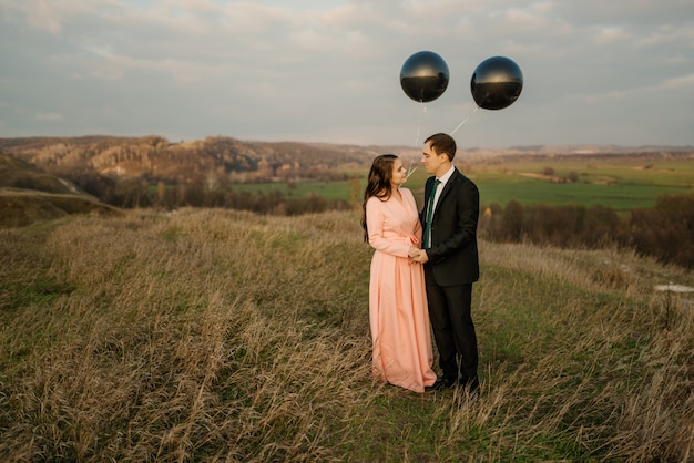 Newlyweds walk in nature with large helium balloons. wedding concept.