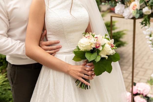 Newlyweds at wedding day, wedding couple with wedding bouquet of flowers, bride and groom