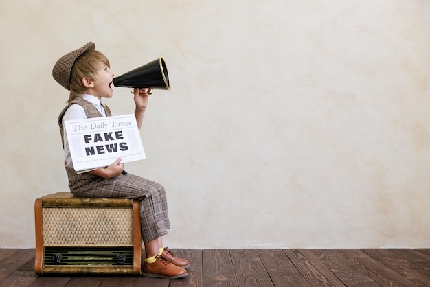 Newsboy shouting against grunge wall background Boy selling fake news