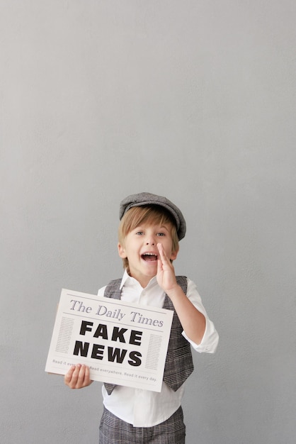 Newsboy shouting against grunge wall background Boy selling fake news