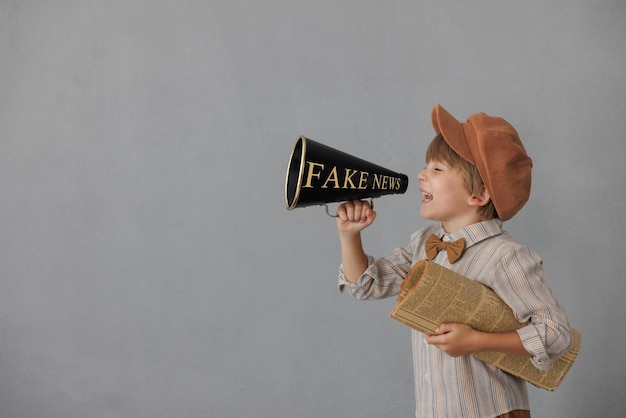 Newsboy shouting against grunge wall background Boy selling newspaper