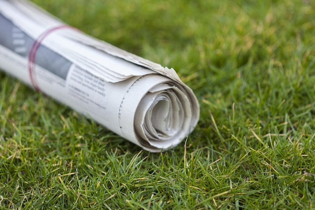 Newspaper on green grass outdoors background