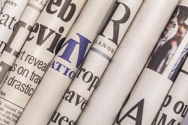 Newspaper headlines shown side on in a stack of daily newspapers