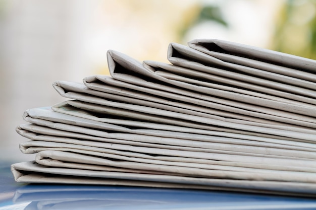 Newspapers folded and stacked on the blue surface and blur background