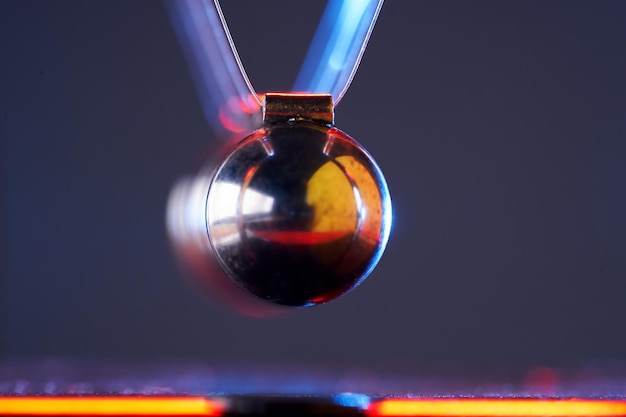 Newton's cradle on isolated gray with colorful lighting