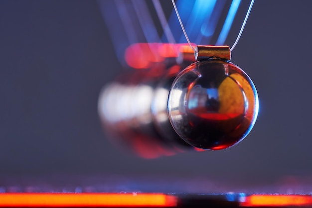 Newton's cradle on isolated gray with colorful lighting