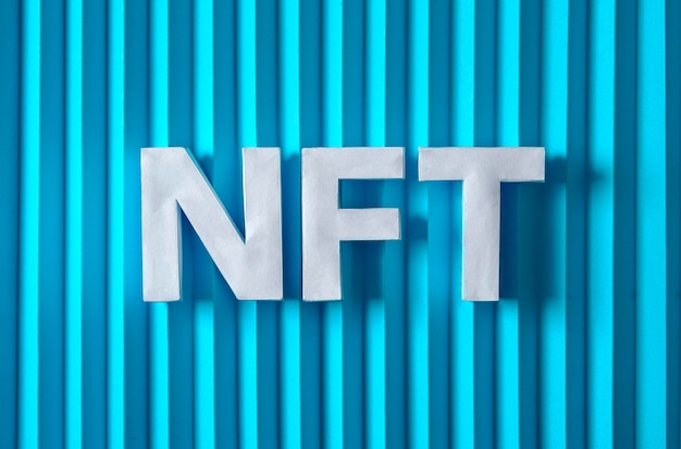 NFT text letters on a blue background Minimal is the concept of digital modern technologies of crypto tokens and sales of the future