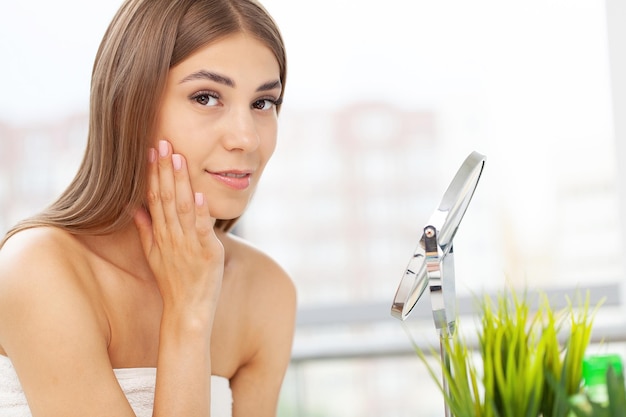 Ng beautiful woman making makeup near mirror